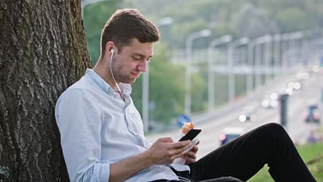 Un-hombre-joven-con-un-móvil-al-aire-libre