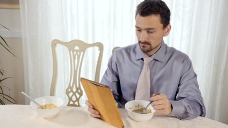 Joven-empresario-come-muesli-con-tablet