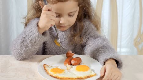 Cute-girl-eats-sausage-with-fork