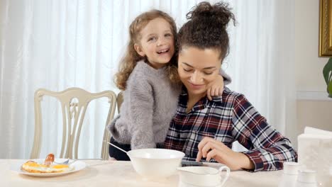 Woman-and-girl-embrace-each-other-during-breakfast