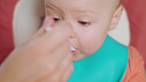 Una-niña-comiendo-puré-en-casa