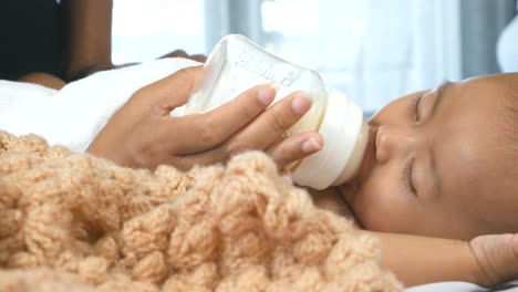 Cute-newborn-baby-girl-sleeping-and-sucking-milk-bottles