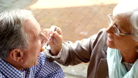 Senior-woman-feeding-sweet-food-to-senior-man-in-café-4k