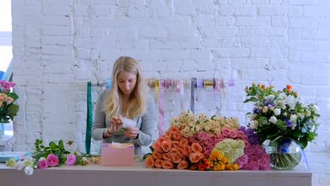 Professional-florist-making-gift-box-with-flowers-at-flower-store