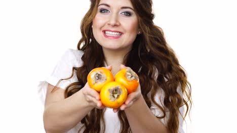 Cheerful-woman-holds-persimmon-kaki-fruits,-isolated