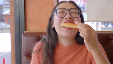 Young-woman-eats-pizza-in-restaurant