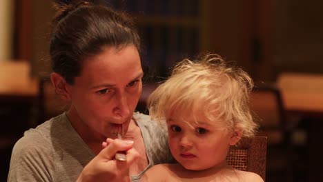 Baby-not-wanting-to-eat-dinner.-Candid-real-life-expressions-of-mother-and-baby-together-at-dinner-table.-Mom-preoccupied-that-toddler-boy-refuses-to-eat