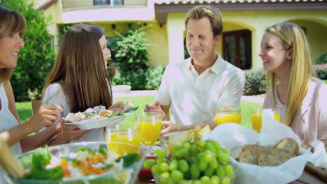 Young-family-dining-outdoors-on-healthy-organic-salad