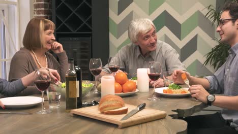 Cheerful-family-communicates-at-dinner-table