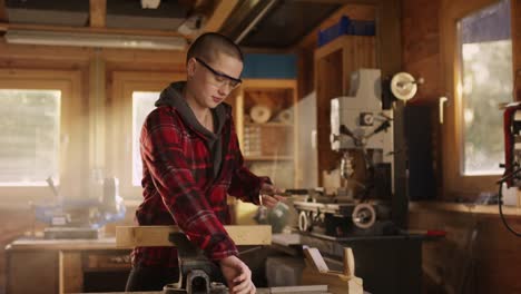 Short-haired-woman-marks-cut-line-on-wooden-plank