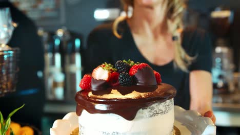 Waitress-Holding-Freshly-Baked-Cake-With-Buttercream-Frosting