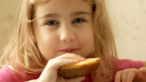 A-little-girl-is-eating-a-sandwich-with-cheese.-The-child-eats-bread-and-cheese.