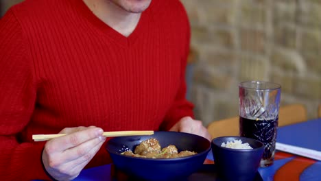 Hombre-come-el-pollo-con-sésamo-y-bebidas-cola-en-el-restaurante-coreano