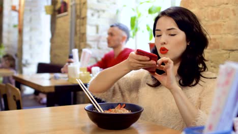 Beautiful-brunette-makes-photo-of-korean-dish-on-her-phone