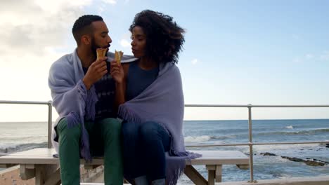 Couple-eating-ice-cream-cone-at-beach-4k