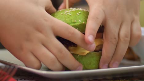 Baby-Hände-nehmen-einen-grünen-hamburger