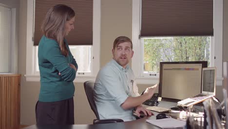 Colleages-gathered-around-a-computer-in-a-bright-office-and-reading-charts