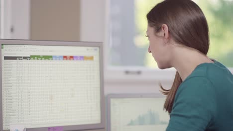 Close-up-of-a-business-woman-in-a-bright-office-entering-data-into-a-computer
