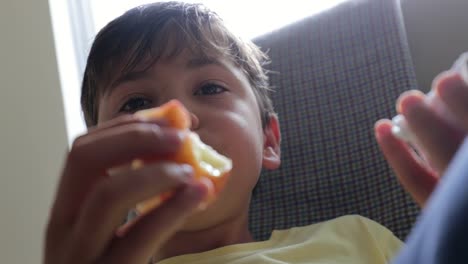 Child-relaxing-while-eating-apple-in-4K