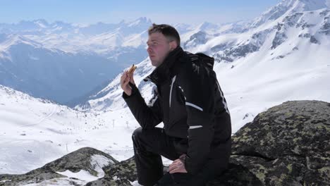 Esquiador-de-hombre-comiendo-un-Sandwich-de-almuerzo-en-la-estación-de-esquí-de-montaña