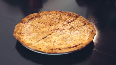 Human-hands,-taking-bits-and-pieces-of-delicious-pizza-from-a-plate.-Close-up