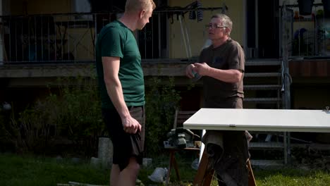 father-and-son-repair-the-inner-doors-in-the-garden-in-the-fresh-air