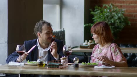 Cheerful-Couple-Eating-Salad-on-Date