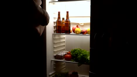 A-fat-man-takes-a-beer-in-the-fridge.