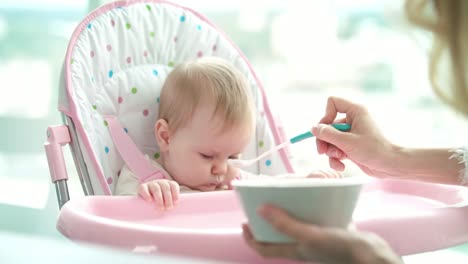 Geistesabwesend-baby-nicht-essen-Püree.-Mutter-Tochter-Fütterung.-Kind-beim-Abendessen