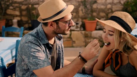 Couple-on-holidays-in-Greece-eating-traditional-food-at-restaurant