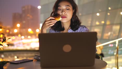 Woman-using-laptop-in-cafe-at-night,4k