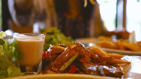 Filete-corte-con-cuchilla-en-la-placa-de-mujer-asiática-en-restaurante-de-lujo.-Concepto-de-dieta-y-comer-sano.