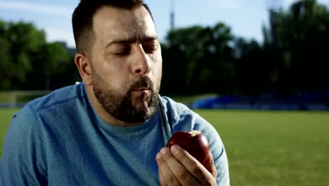 Hombre-feliz-con-apple-en-el-campo-de-atletismo