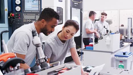 Zwei-Ingenieure-diskutieren-Pläne-für-Job,-während-am-Laptop-auf-der-Suche