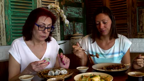 Las-mujeres-comen-y-hablan-mientras-está-sentado-en-una-mesa-en-un-restaurante-vietnamita