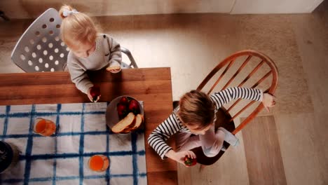 Vista-desde-arriba-de-las-niñas-comer-de-merienda-en-casa