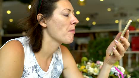 Frau-in-einem-Restaurant-Essen-und-genießt-eine-Smartphone