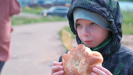 Junge-auf-der-Straße-eine-Brötchen-zu-essen.