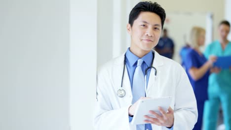 Portrait-of-Asian-American-male-doctor-using-technology