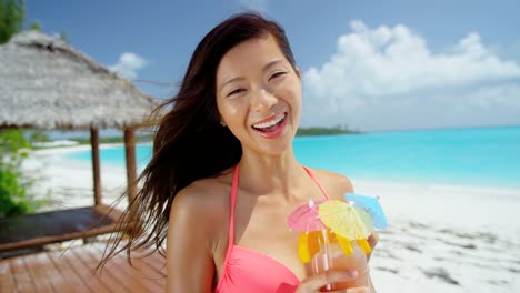 Lächelnd-ethnischen-weibliche-genießen-bunten-Cocktail-am-Strand