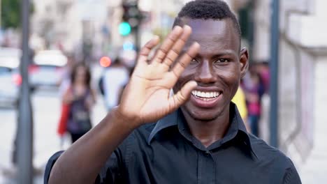 happy-young-black-man-african-greets-the-camera---outdoor--slow-motion