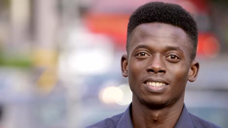 black-american-youn-man-in-the-street-raising-his-head-and-smiles-at-camera