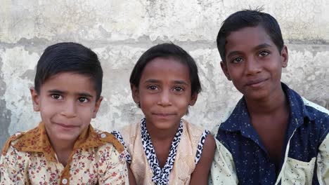 Drei-indische-Kinder-sitzen-und-schaut-in-die-Kamera-und-sprechen