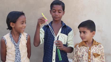 Indian-kids-friends-blowing-soap-bubbles-and-playing-around