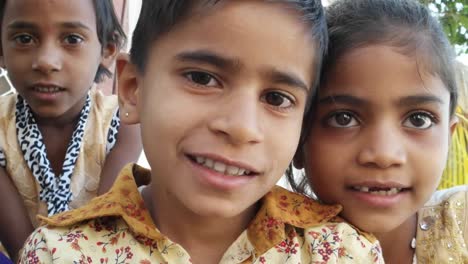Indian-kids-looking-at-the-camera-smiling,-closeup-handheld
