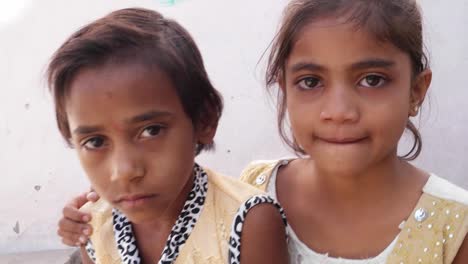 Two-sisters-looking-at-the-camera-with-a-serious-and-sad-face,-dolly-in-and-out