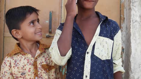 Indische-Kinder-sprechen-auf-mobile-Handy,-aufgeregt-und-glücklich,-reden-Brüder-Geschwister