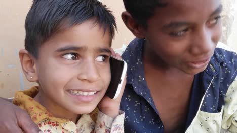 Indian-kids-talking-on-mobile-cell-phone,-excited-and-happy,-talking