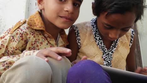 Kids-busy-working-on-a-touch-screen-tablet-and-discussing,-India