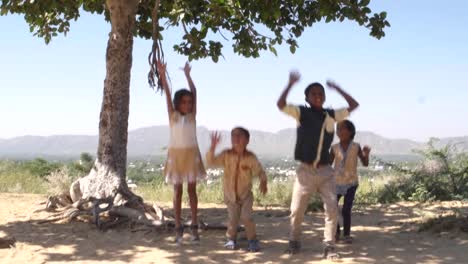 Indian-children-portrait-happy-and-excited,-playing-and-making-merry-in-sand-area-in-Rajasthan-state-of-India